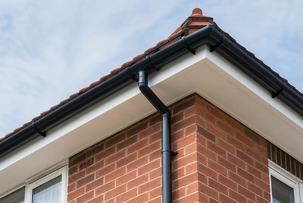 New black uPVC fascias, soffits and guttering on a red-brick house